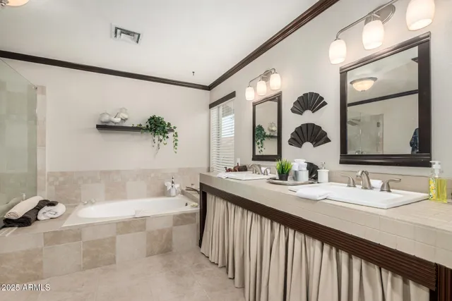a bathroom with a tub a sink and mirror