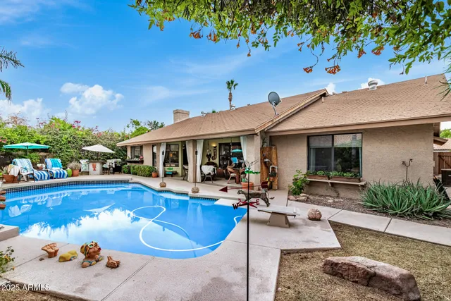 a view of a house with swimming pool and sitting area