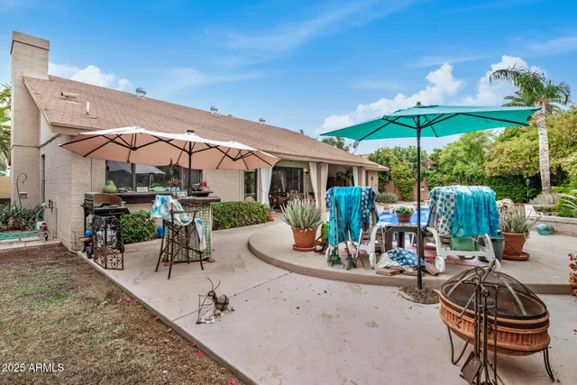 a view of a patio with a dining table and chairs under an umbrella