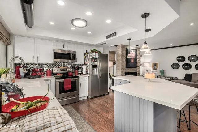 a kitchen that has a lot of cabinets and refrigerator in it