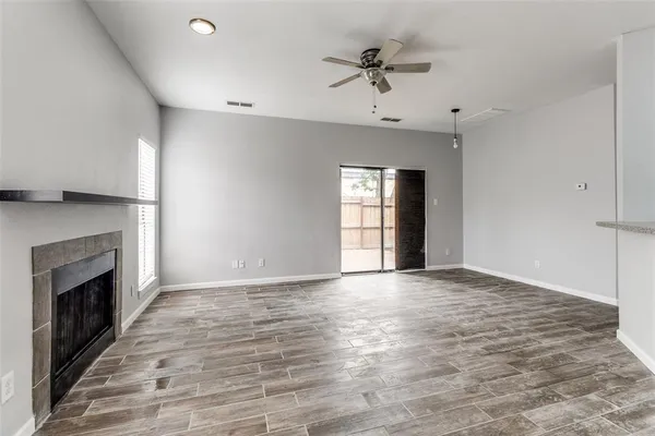 a view of an empty room with a fireplace and a window