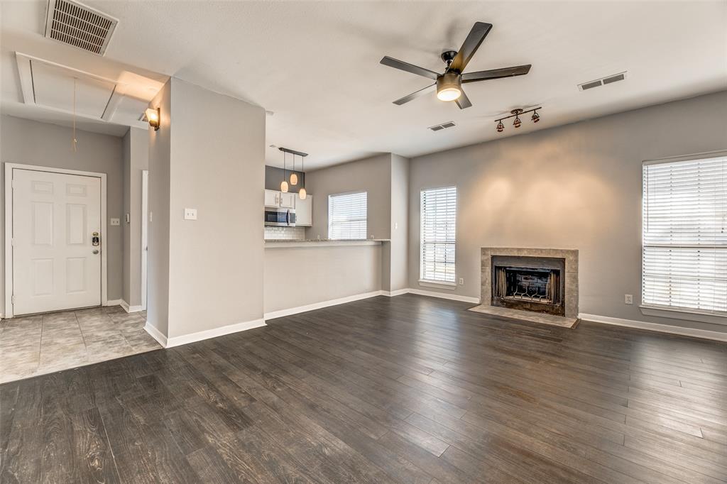 2815 Reagan Street Dallas, TX 75219 - Photo 29 of 40 an empty room with wooden floor a ceiling fan and windows