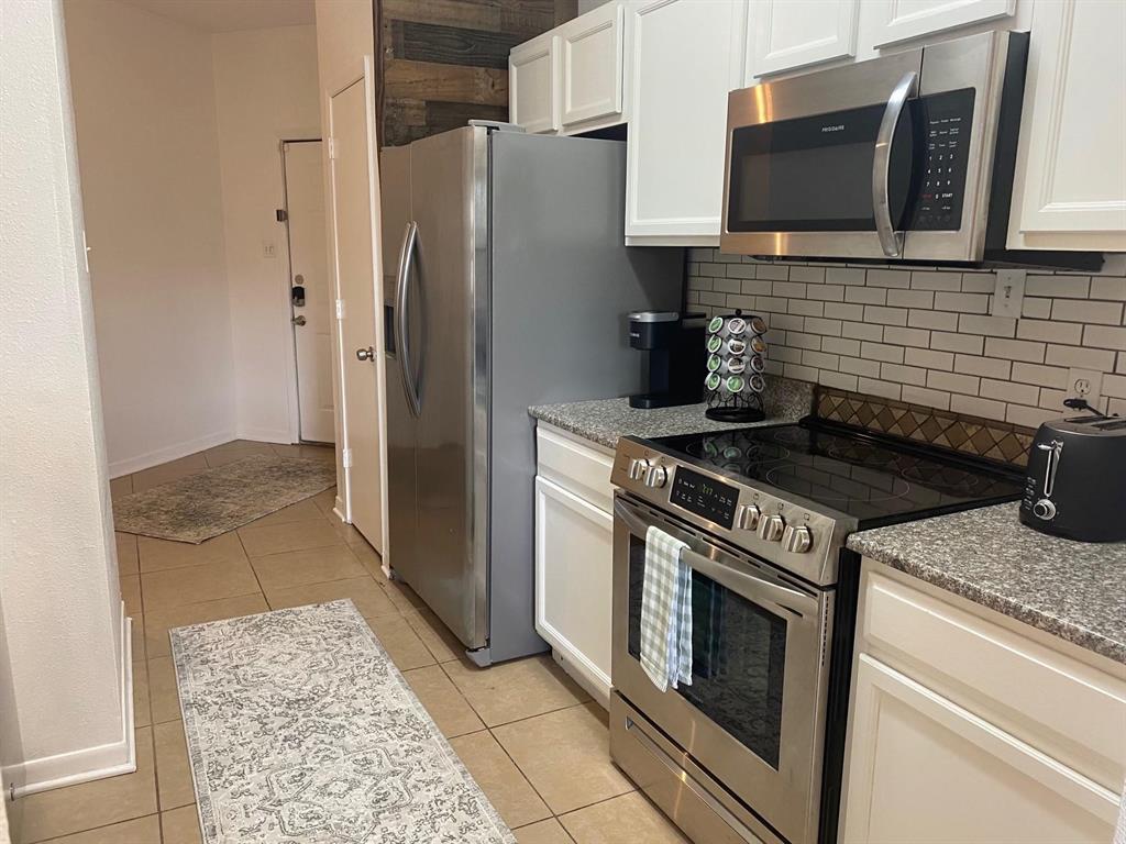 2815 Reagan Street Dallas, TX 75219 - Photo 36 of 40 a kitchen with a stove and a refrigerator