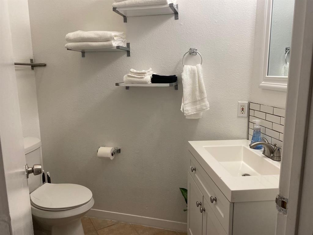 2815 Reagan Street Dallas, TX 75219 - Photo 40 of 40 a bathroom with a sink a toilet and a mirror