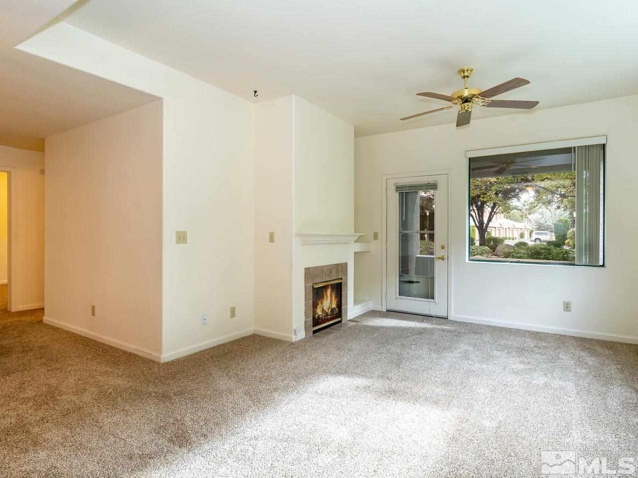 900 South, Unit 214 Reno, NV 89521 - Photo 3 of 22 a view of a livingroom with a fireplace a ceiling fan and window
