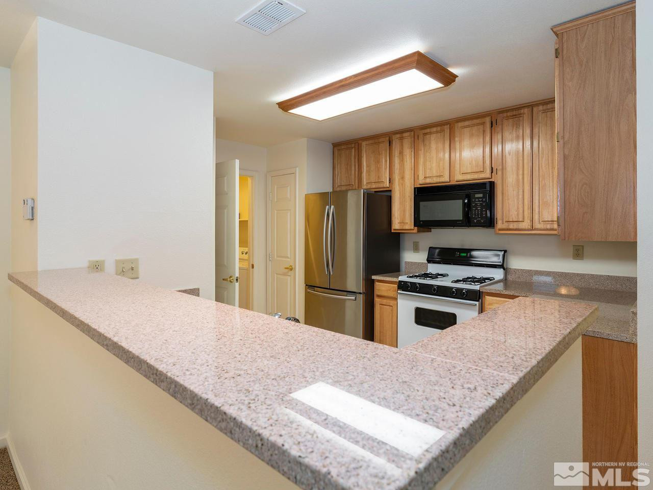 900 South, Unit 214 Reno, NV 89521 - Photo 6 of 22 a kitchen with stainless steel appliances granite countertop a sink stove and refrigerator