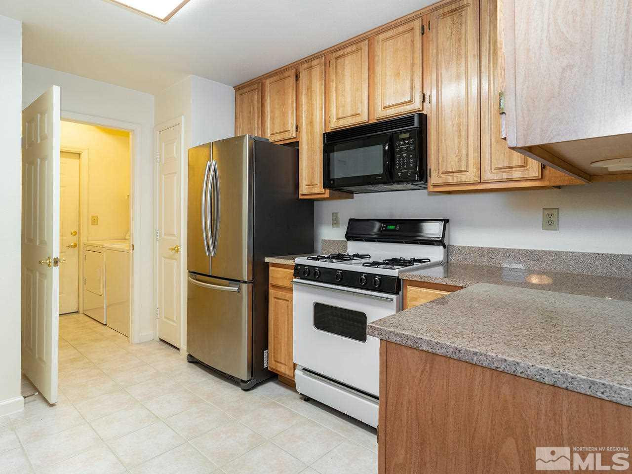 900 South, Unit 214 Reno, NV 89521 - Photo 7 of 22 a kitchen with stainless steel appliances granite countertop a refrigerator stove and microwave