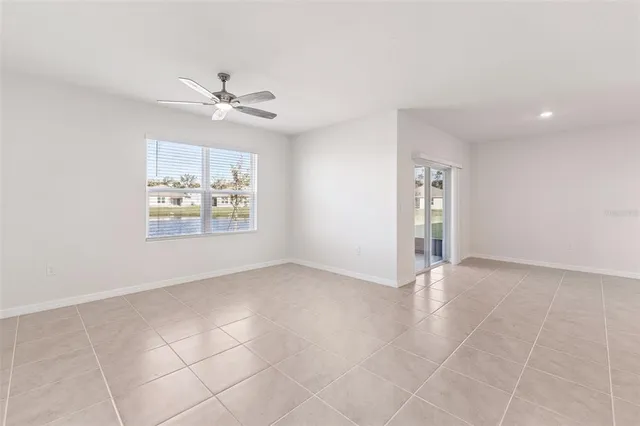 an empty room with windows and fan