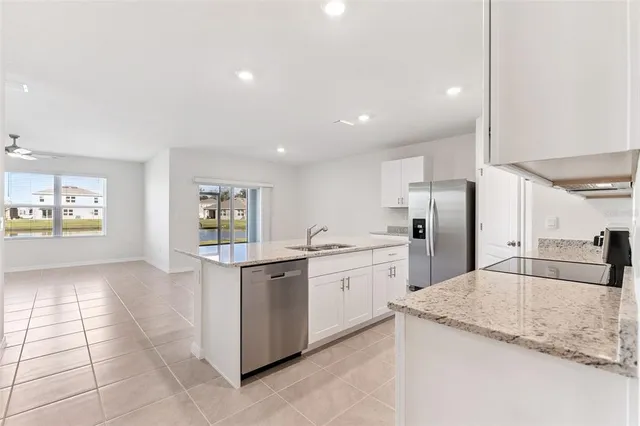 a kitchen with stainless steel appliances granite countertop a refrigerator and a sink