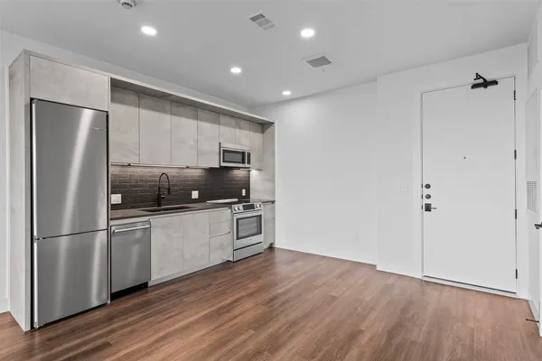 a kitchen with cabinets stainless steel appliances and a counter space