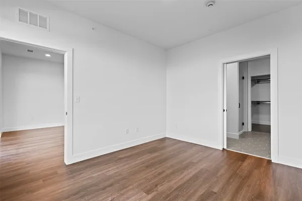 an empty room with wooden floor and sliding door