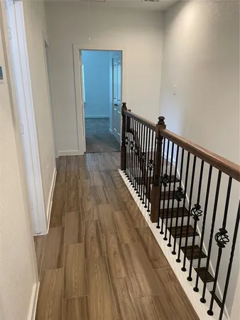 a view of a hallway with wooden floor
