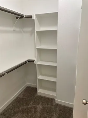 a view of walk in closet with empty racks