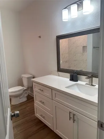 a bathroom with a toilet sink and mirror