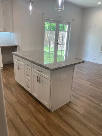 a kitchen with granite countertop wooden cabinets and a sink