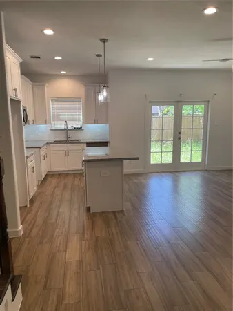 a kitchen with a wooden floor and window
