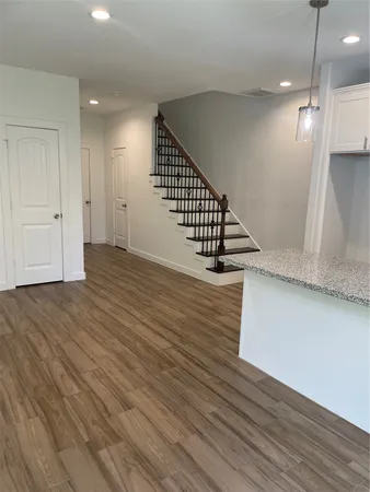 a view of a hallway with wooden floor and staircase