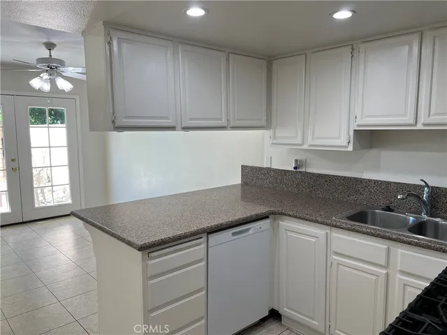 a kitchen with granite countertop white cabinets and a sink