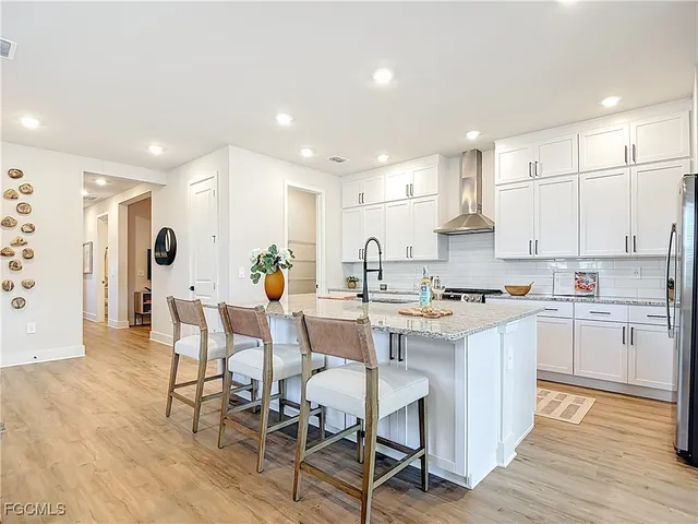 a kitchen with stainless steel appliances a table and chairs in it