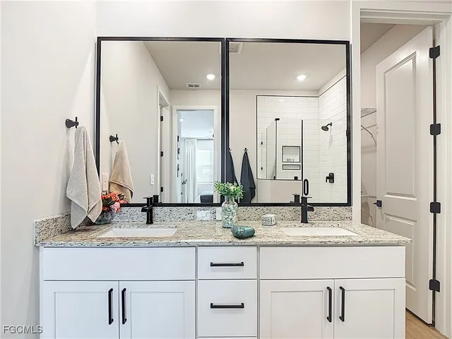 a bathroom with double vanity sinks and a mirror