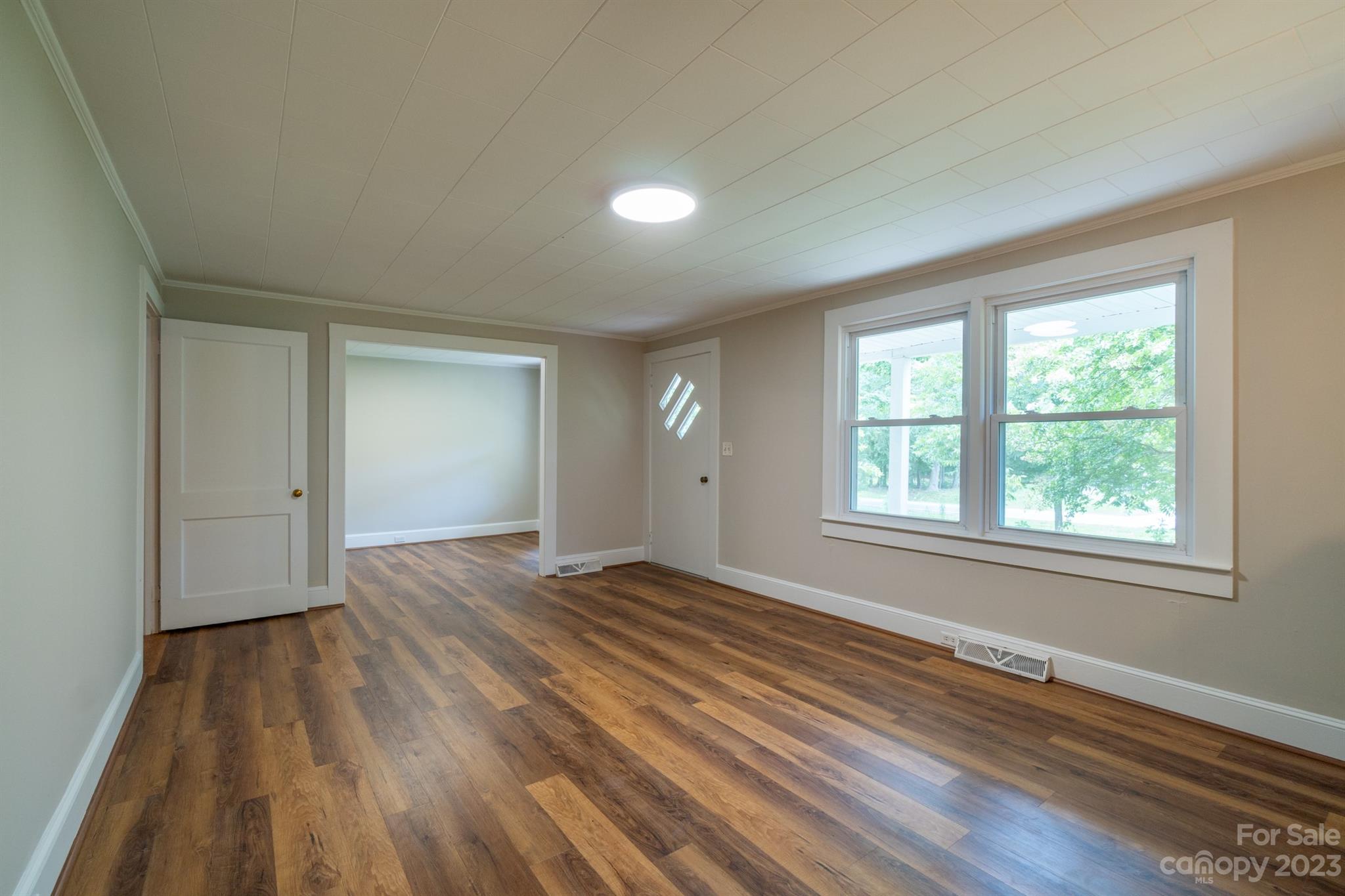 17158 Pond Road Locust, NC 28097 - Photo 7 of 28 an empty room with wooden floor and windows