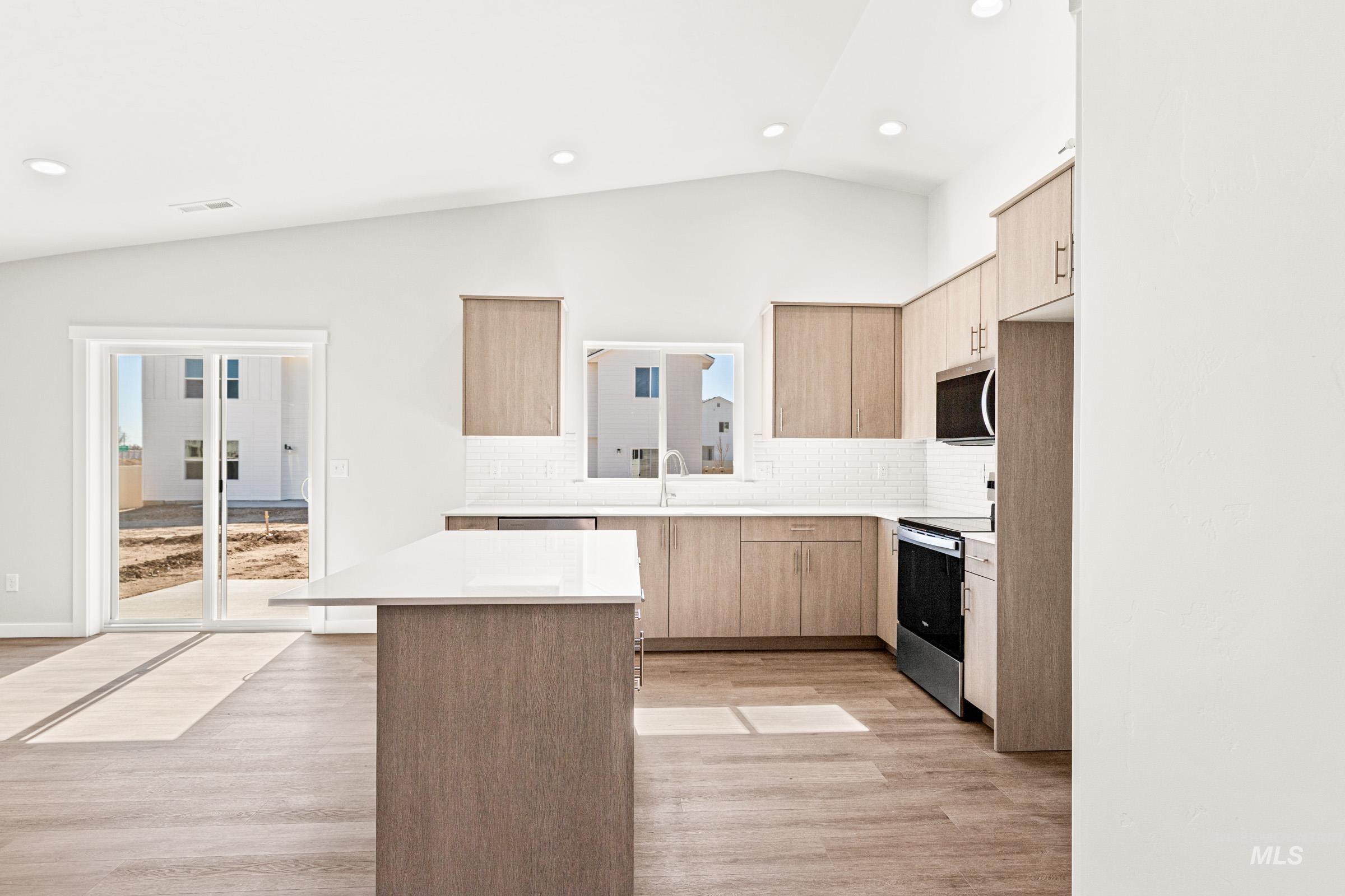 1077 West Jasper Street Meridian, ID 83642 - Photo 4 of 19 Modern kitchen featuring light wood-finish cabinetry, white subway tile backsplash, and stainless steel appliances