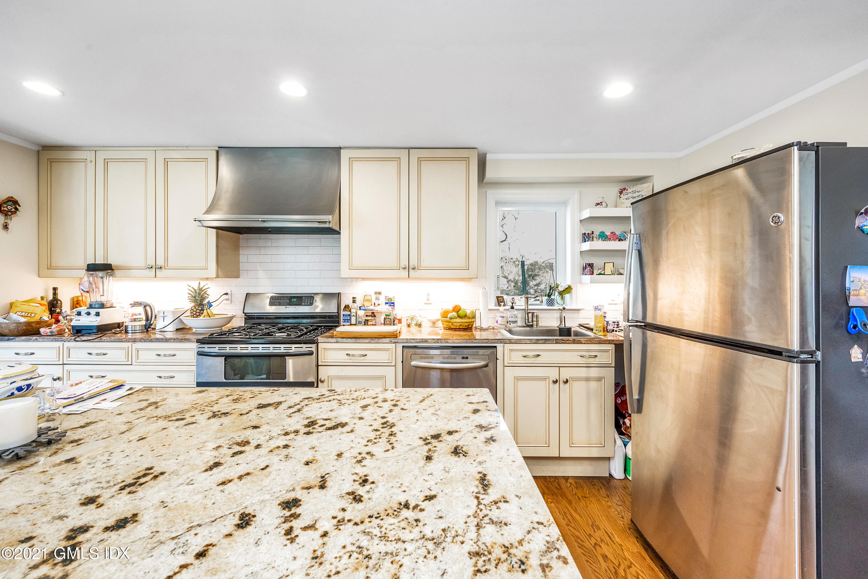 33 Sunshine Avenue Riverside, CT 06878 - Photo 4 of 18 a kitchen with granite countertop a refrigerator a sink and white cabinets