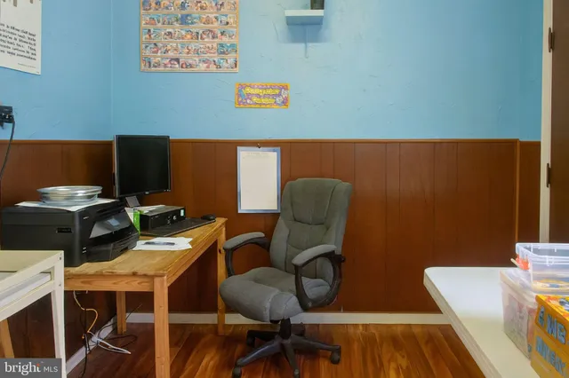 a view of a workspace with furniture and wooden floor