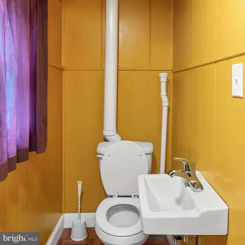 a bathroom with a toilet sink and mirror