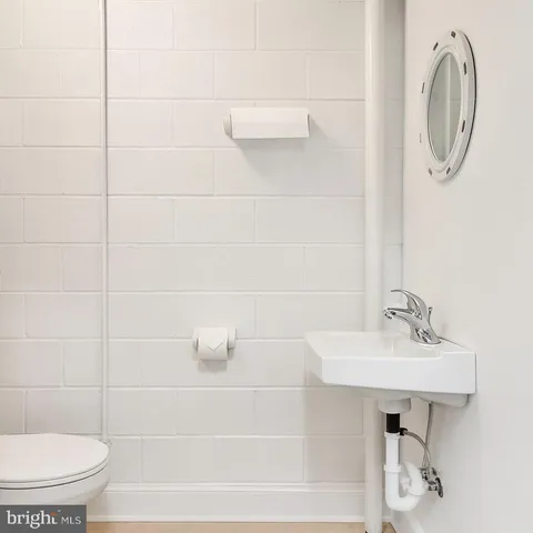 a bathroom with a sink a toilet and a mirror