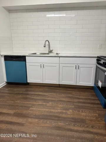 a view of a kitchen with white cabinets