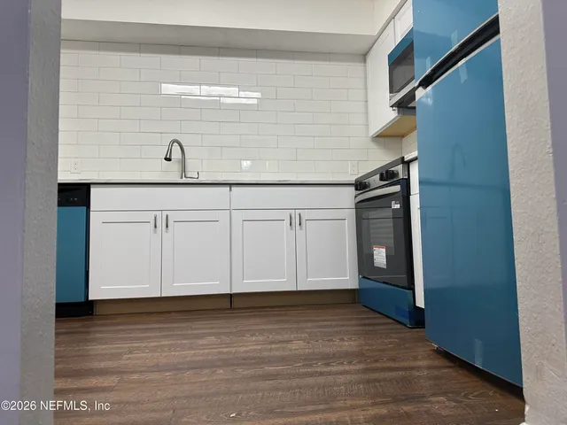 a view of a livingroom with wooden floor and cabinet