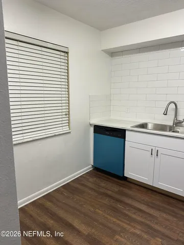 a kitchen with a sink cabinets and a wooden floor