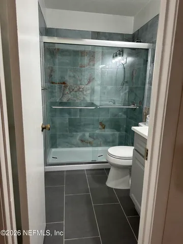 a bathroom with a toilet and a shower