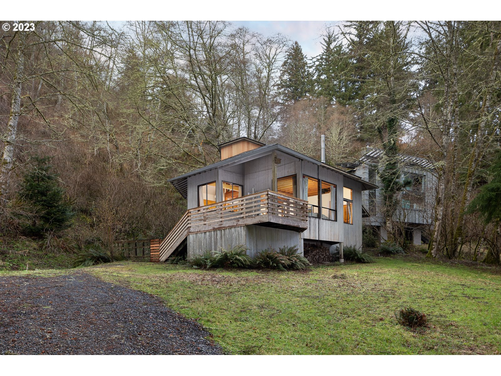 2170 Old Ranch Road Otis, OR 97368 - Photo 1 of 32 a front view of a house with a garden and trees