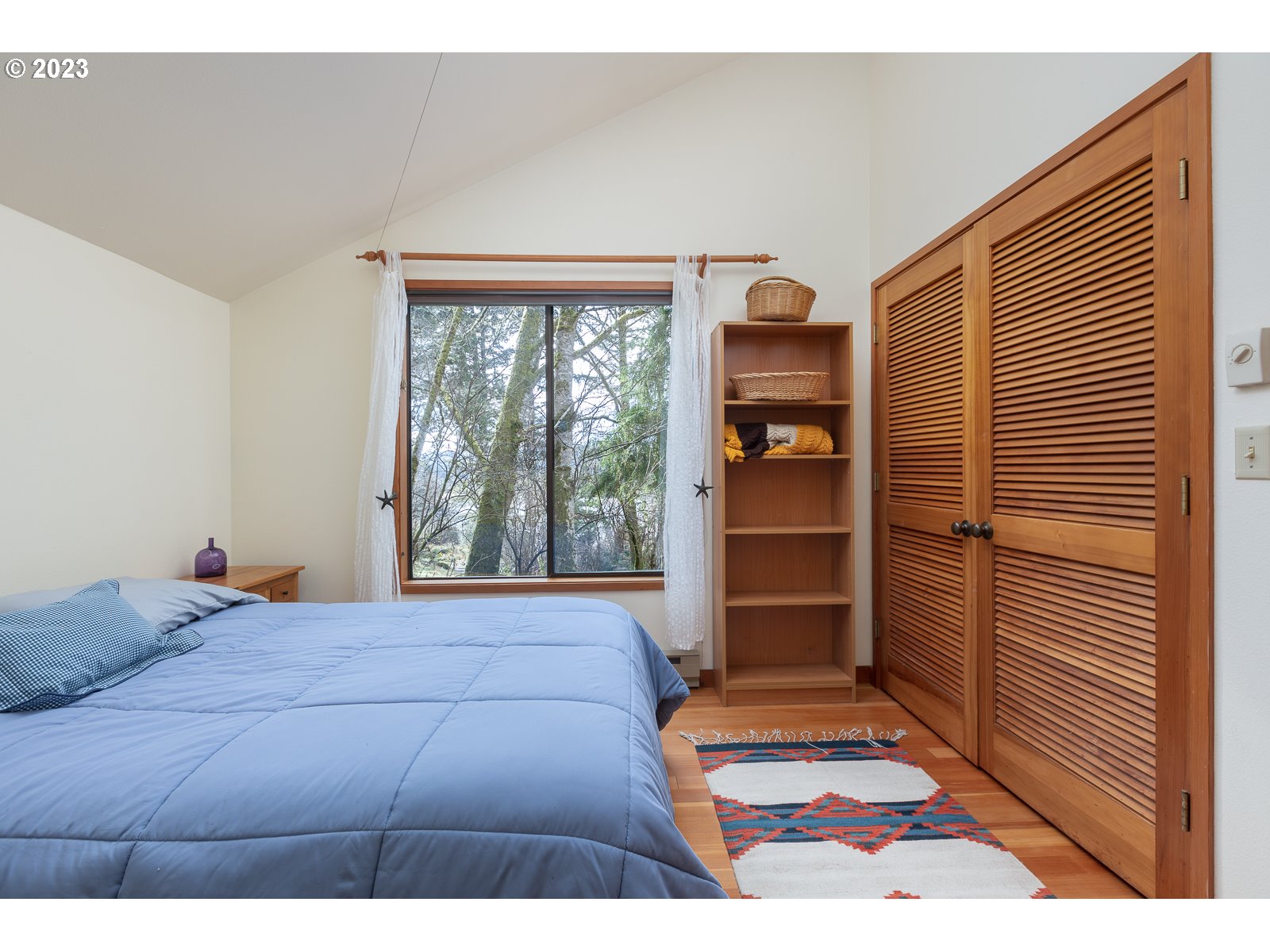 2170 Old Ranch Road Otis, OR 97368 - Photo 18 of 32 a bedroom with a bed and a large window