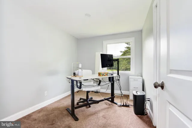 a view of a workspace with furniture and a window