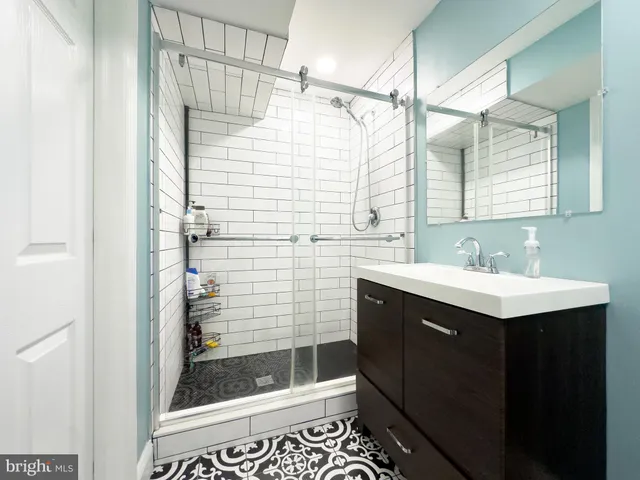 a bathroom with a sink a mirror and shower