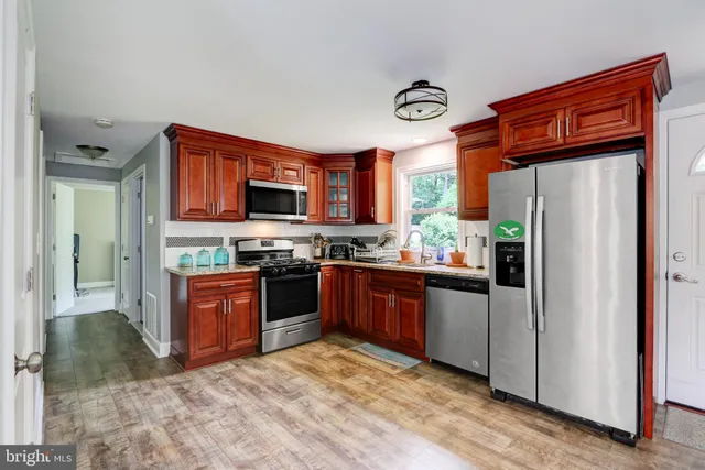 a kitchen with stainless steel appliances granite countertop a refrigerator oven a stove top oven a sink and dishwasher