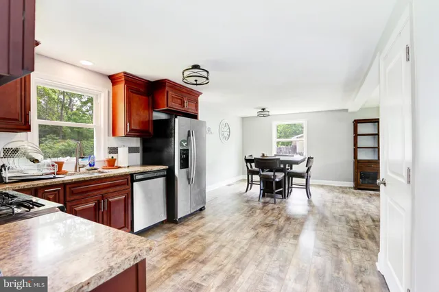 a kitchen with stainless steel appliances granite countertop a refrigerator and a stove top oven