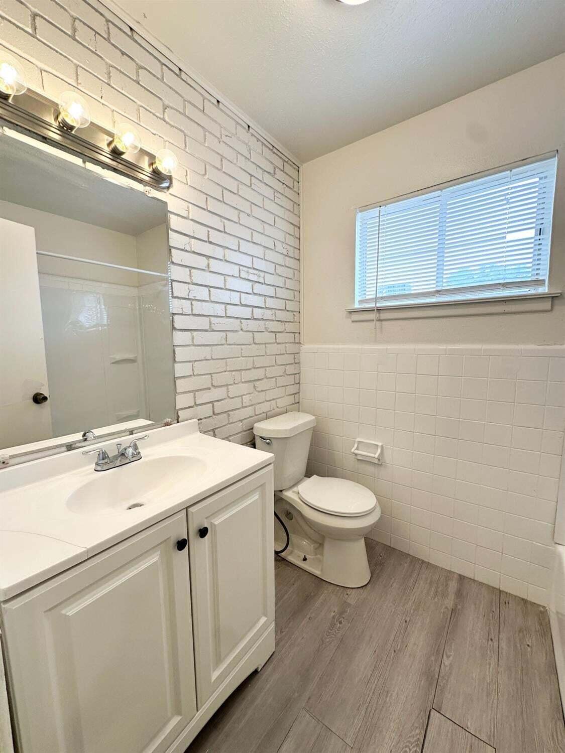 1303 65th Street Lubbock, TX 79412 - Photo 8 of 11 a bathroom with a sink a toilet and mirror