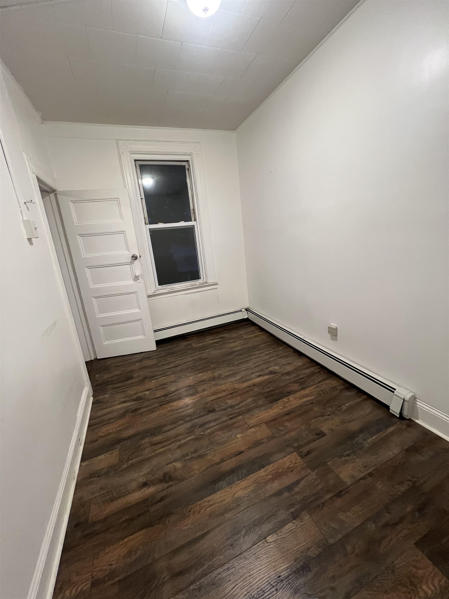 1511 46th Street, Unit 2 North Bergen, NJ 07047 - Photo 7 of 13 a view of an empty room with wooden floor and stairs