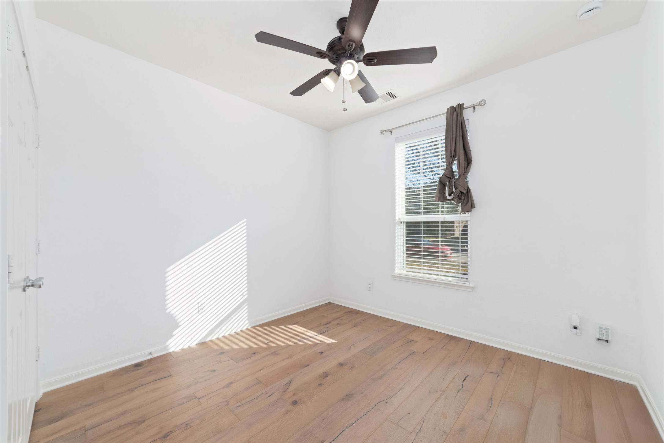 3508 Saxton Green Road Pearland, TX 77584 - Photo 6 of 45 an empty room with wooden floor fan and windows