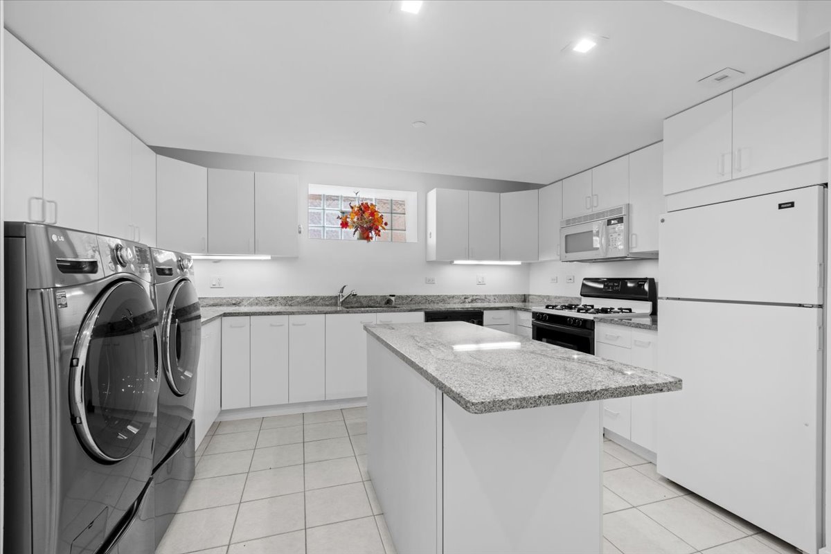 1261 West Flournoy Street Chicago, IL 60607 - Photo 33 of 43 a kitchen with granite countertop a sink a stove a refrigerator and white cabinets