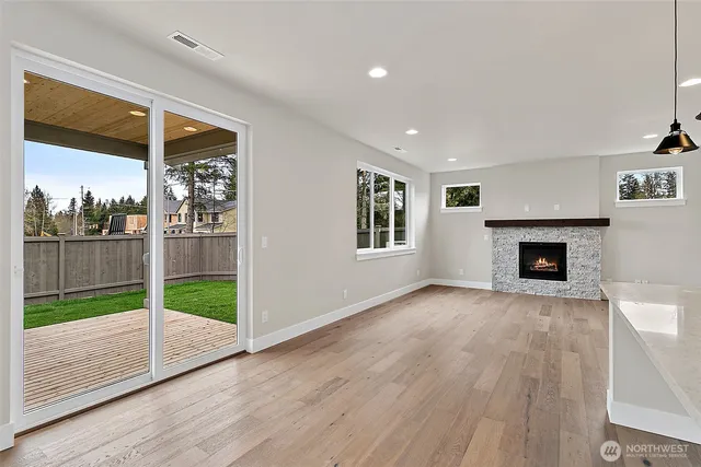 a view of an empty room with a fireplace and a window