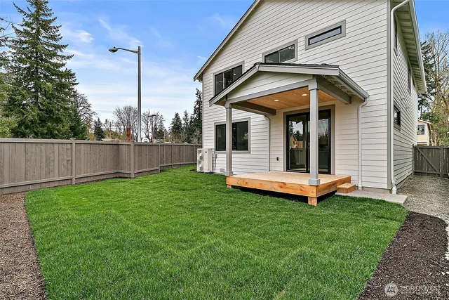 a view of a small house with wooden fence