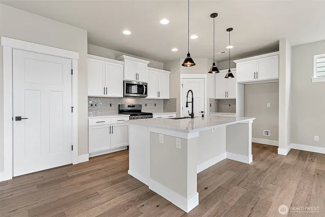 a kitchen with white cabinets and stainless steel appliances