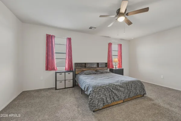 a bedroom with a bed dresser and window