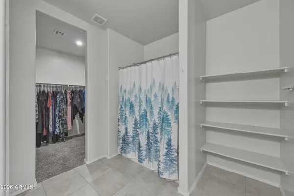 a view of walk in closet with clothes and shoes