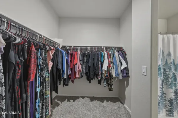 a view of walk in closet with clothes
